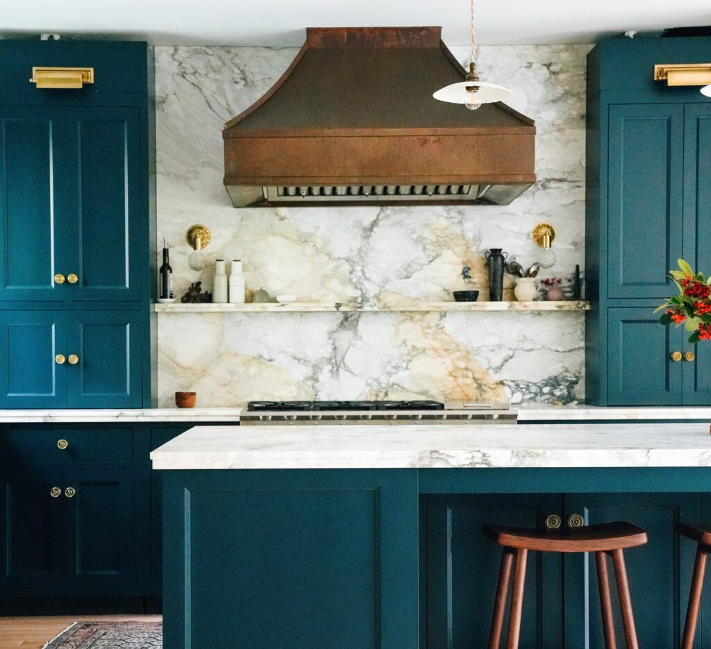 Turquoise blue cabinets complimented by IRG's Calacatta Paonazzo Marble with copper and gold accents.