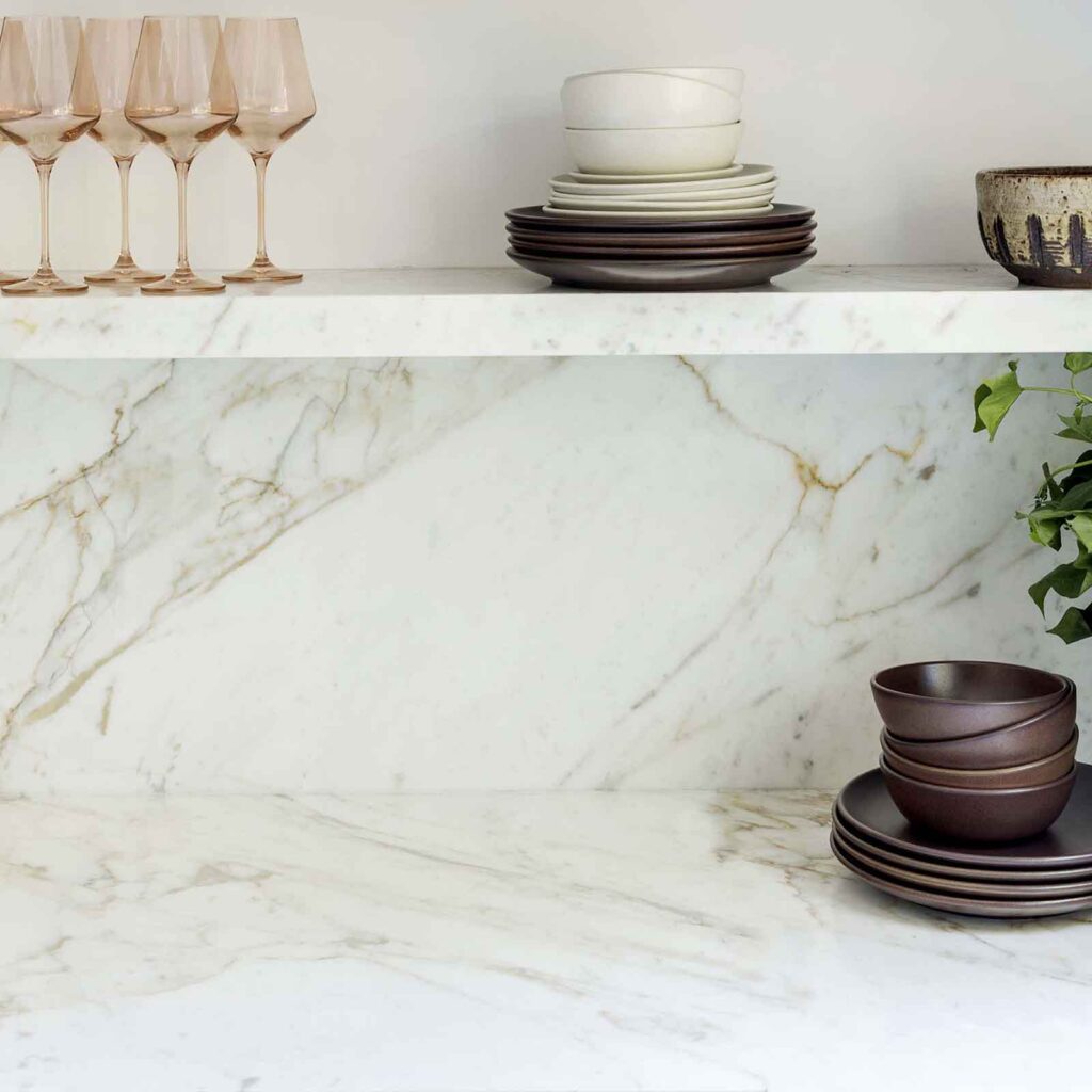 Calacatta Vagli Marble shown as backsplash, shelf and counter surface in kitchen nook setting.