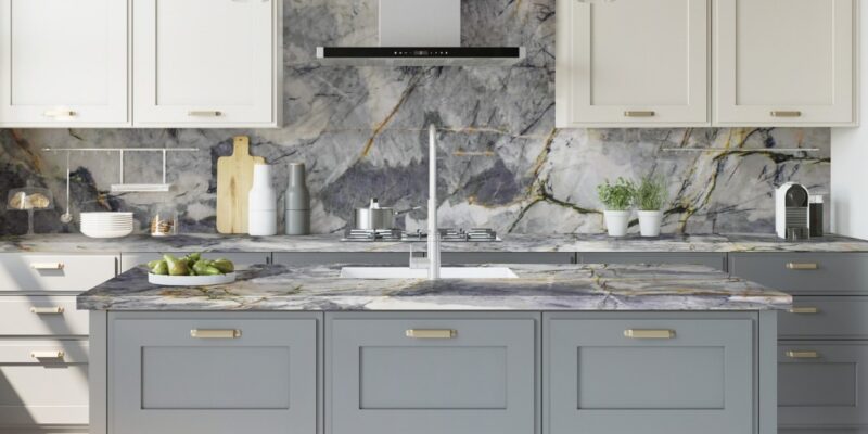 Beach-inspired kitchen with blue-toned quartzite countertops and backsplash, complemented by light gray and white cabinetry, and pendant lighting