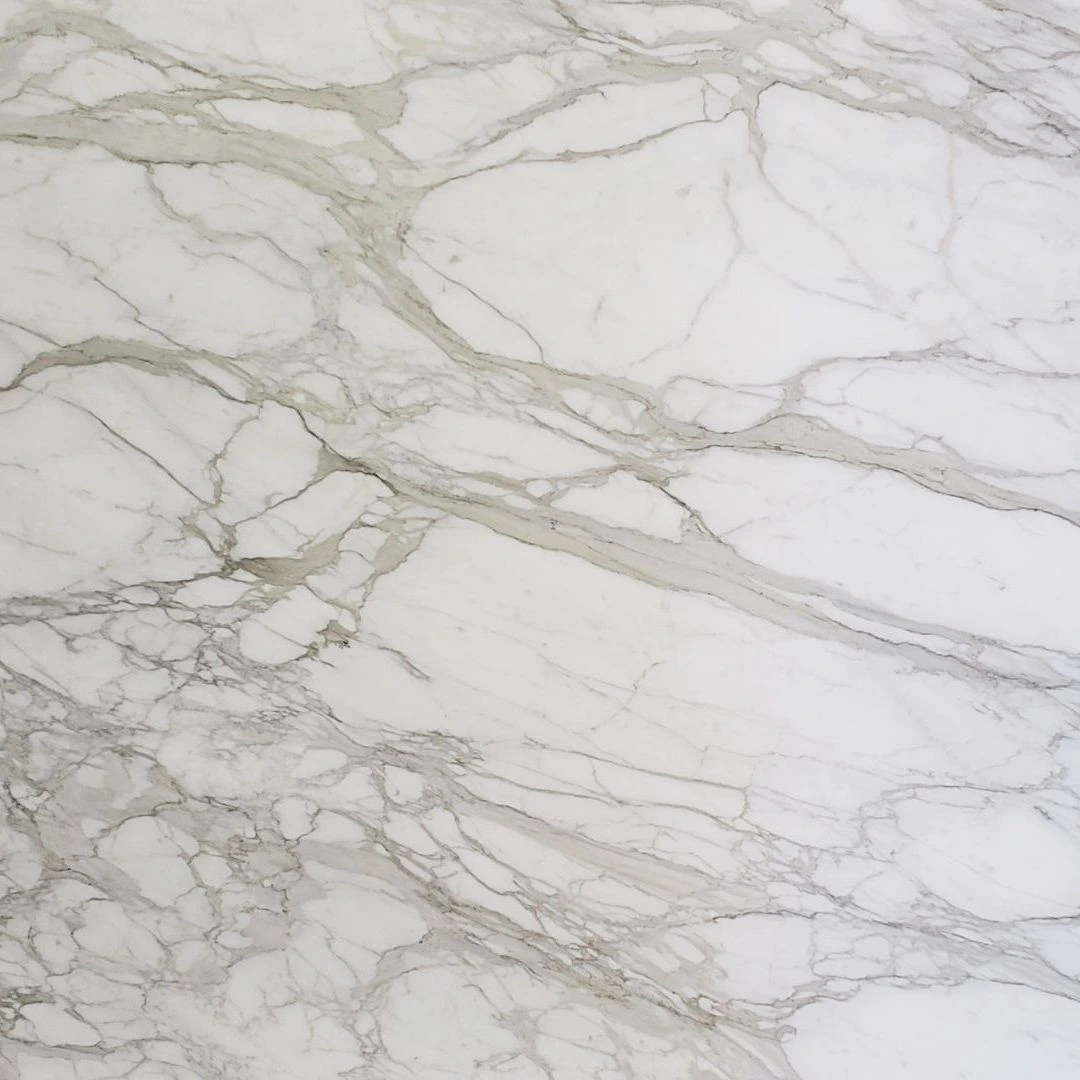 Calacatta Oro Deluxe honed marble slab with soft golden veining on a creamy white base, ideal for luxury kitchen islands and bathroom backsplashe